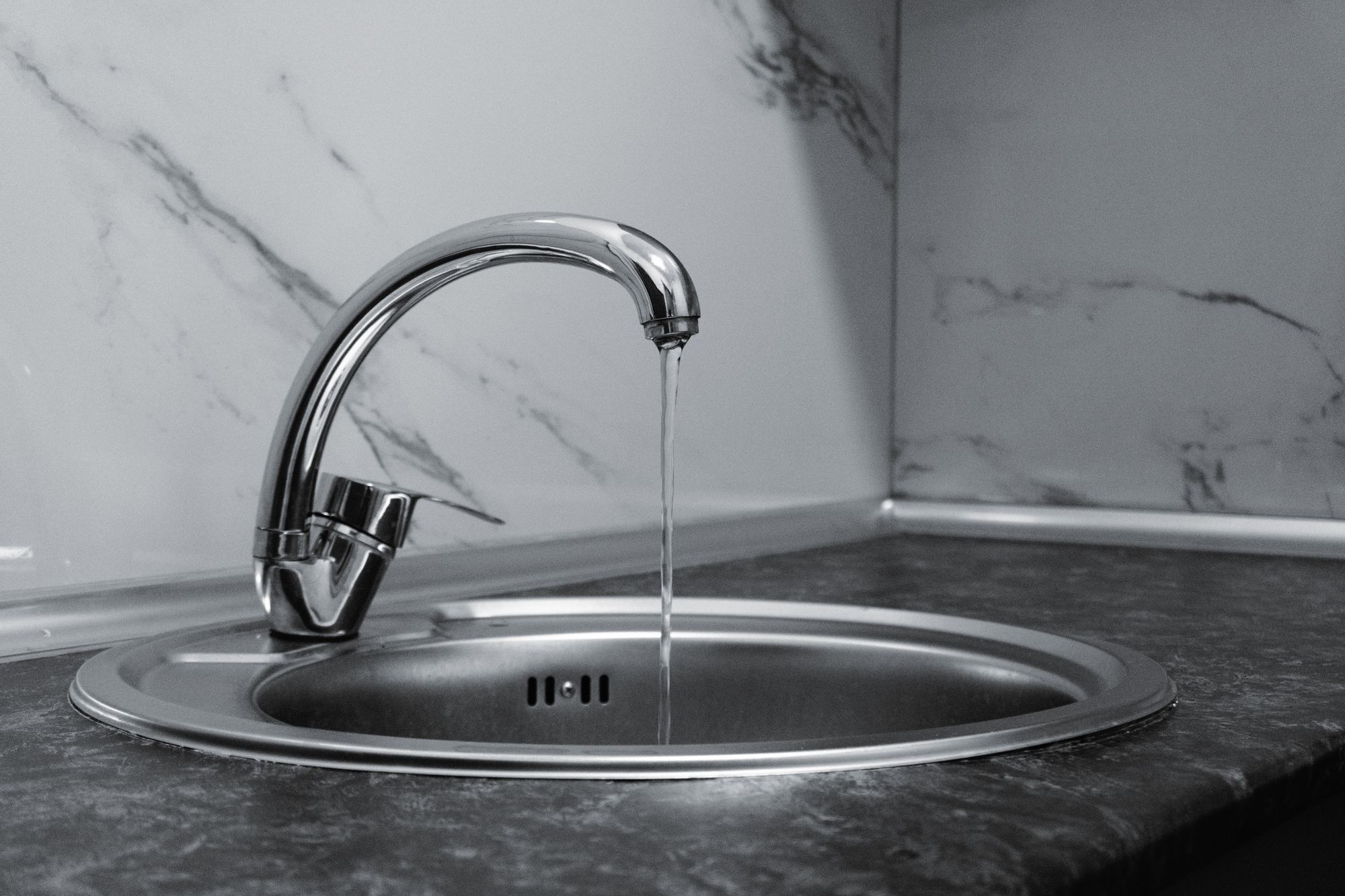 Water running from a chrome kitchen faucet